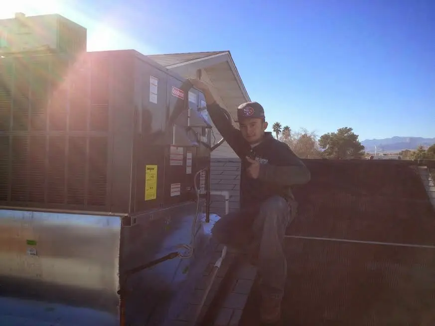 HVAC technician performing AC Tune-Up on a rooftop unit in River Park